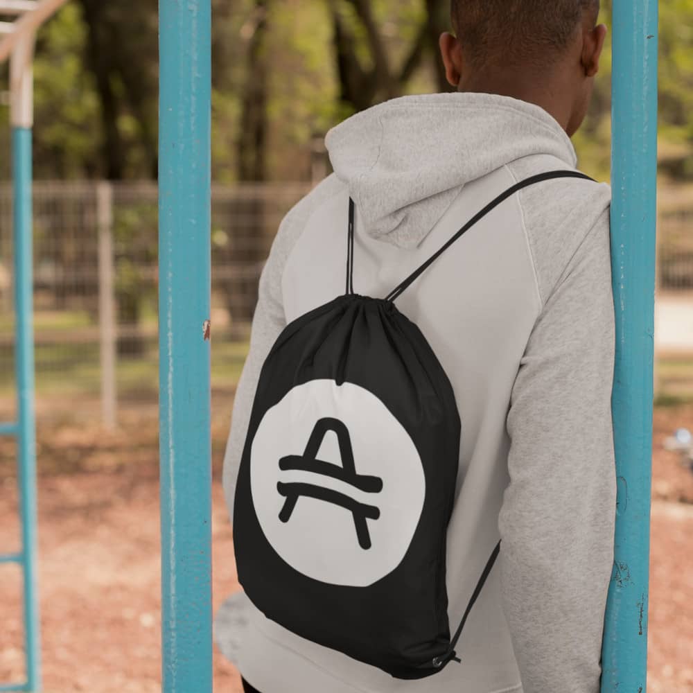 Man wearing a black AMP Token AMP Swagg Drawstring bag with a white AMP Token Logo