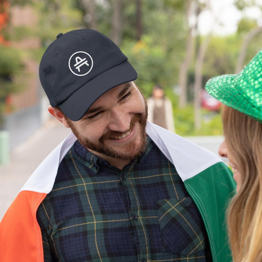 Man wearing a dark navy AMP Token AMP Swagg alt-logo cap