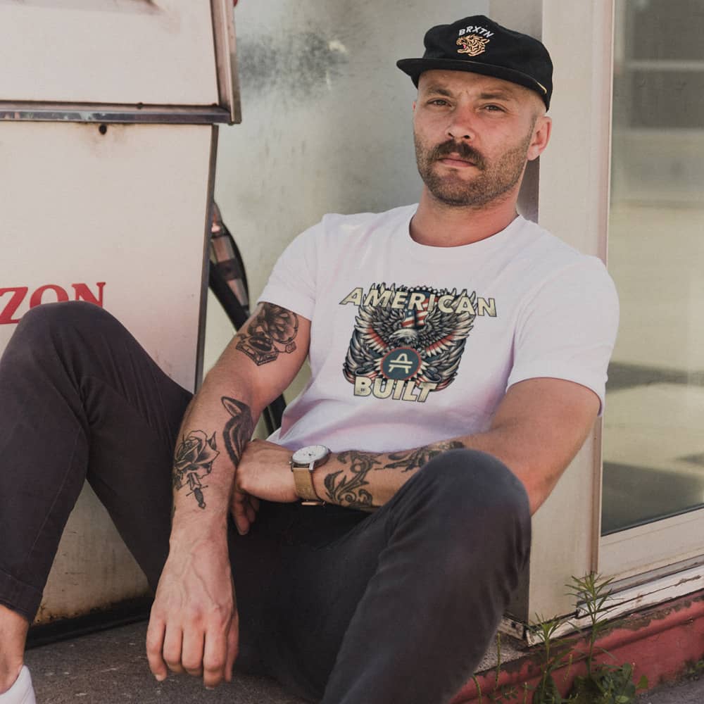 A man wearing an AMP swagg AMP American Built T-Shirt in White