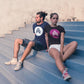 Couple Wearing AMP Token Solid Alt Logo Shirts in a dark navy and black color