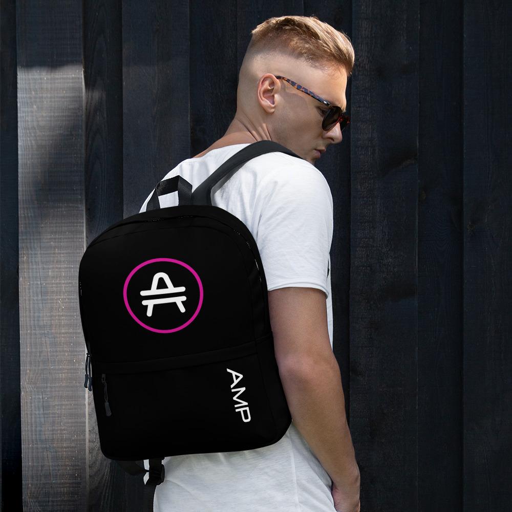 A man wearing A black AMP Token AMP Swagg Stenciled backpack
