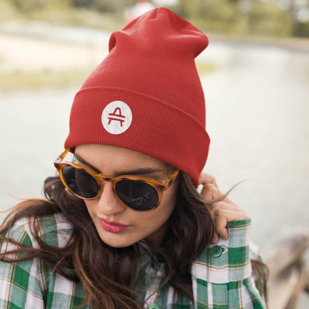 Woman with glasses wearing a red AMP Token AMP swagg beanie