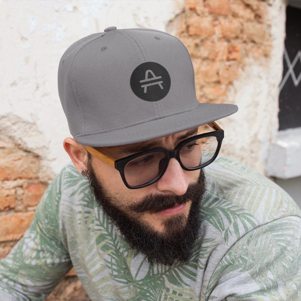 Hipster with glasses wearing a silver AMP Token AMP swagg alt-logo snapback