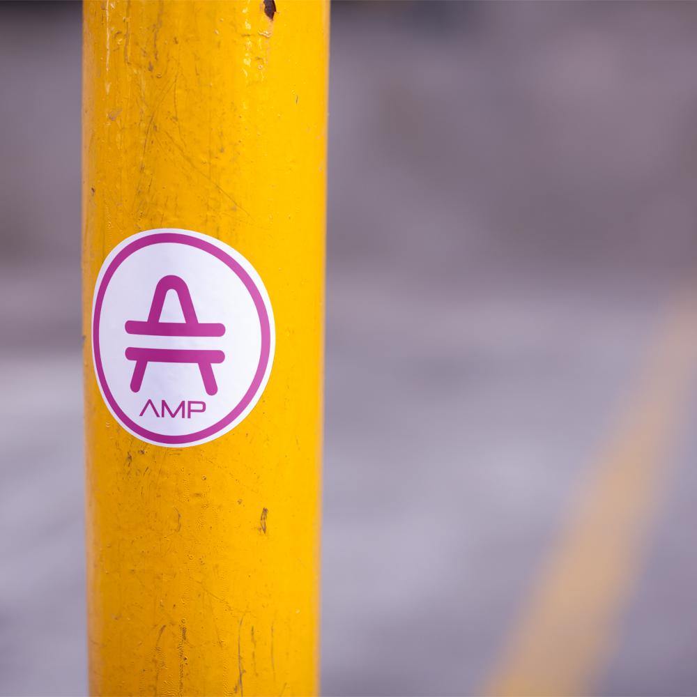 AMP Token Alt-logo Lambda Sticker in a medium size stuck on a yellow pole