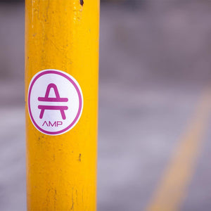 AMP Token Alt-logo Lambda Sticker in a medium size stuck on a yellow pole