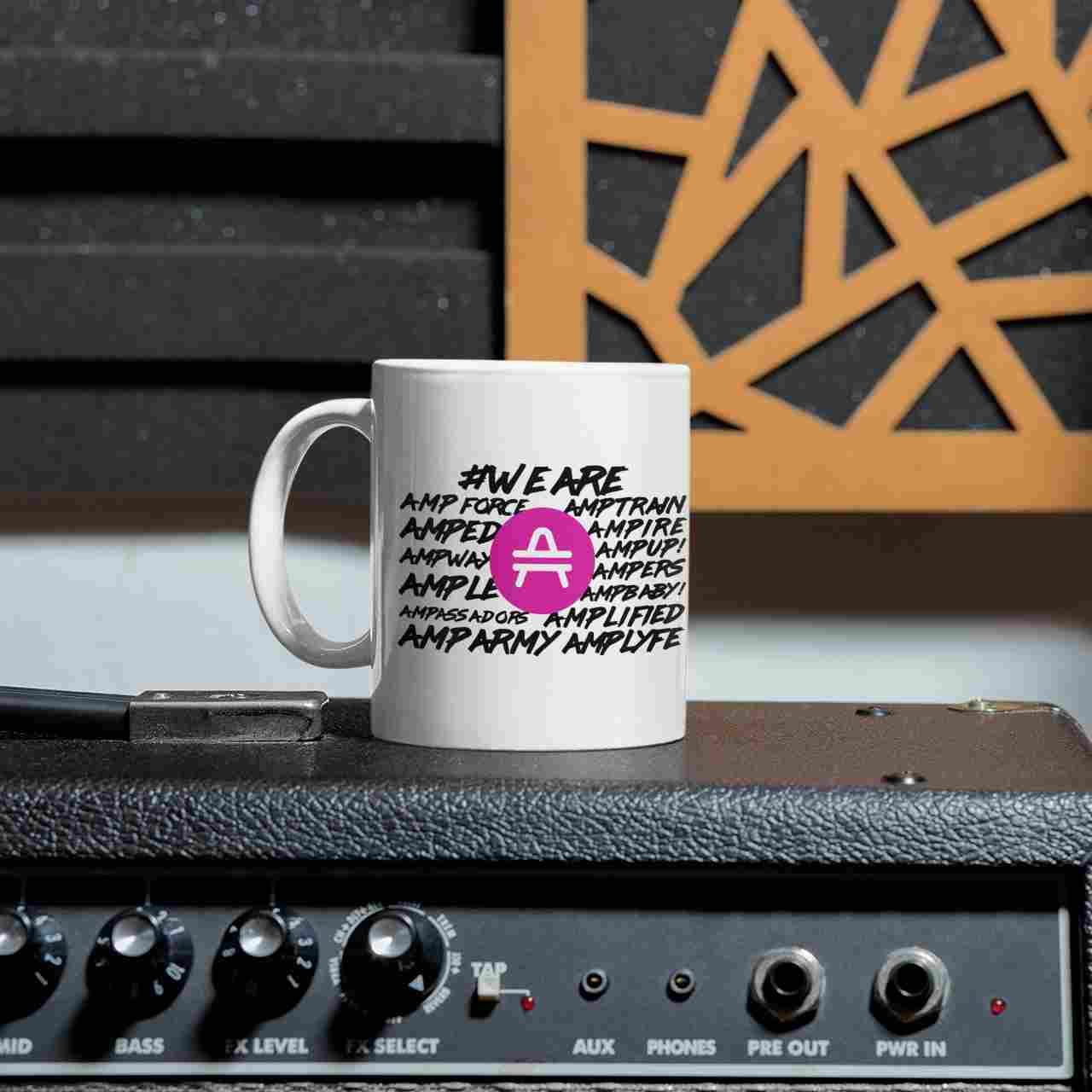 AMP Token White Mug #WE-ARE 11oz in white sitting on a stereo speaker