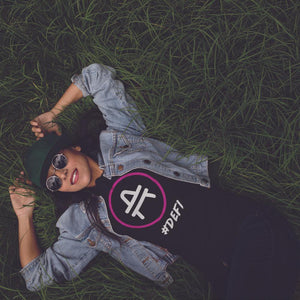 Woman lying in grass wearing AMP token AMP swagg Defi Shirt in a black color