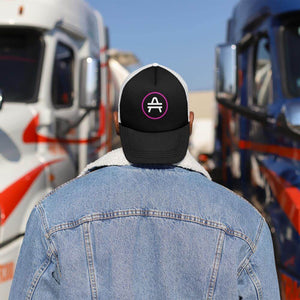 A guy wearing a black AMP Token AMP swagg alt-logo Trucker hat